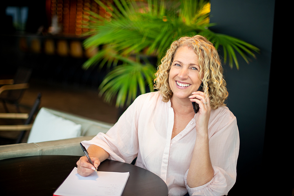Photograph of a person working at a desk with a laptop in a bright office